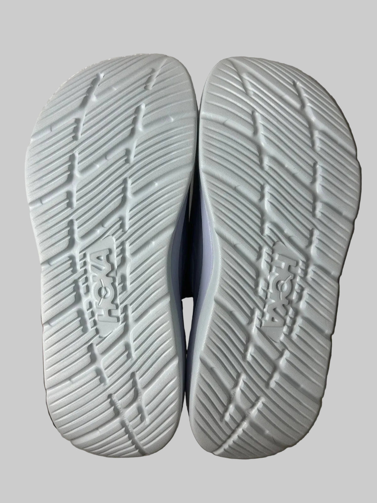 Close-up of the sole of a shoe with tread pattern on a gray background