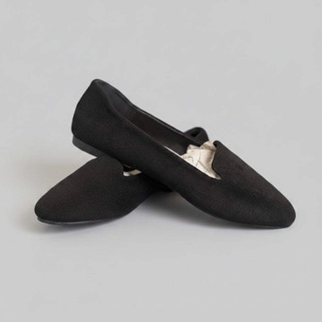 Pair of black slippers on a gray background