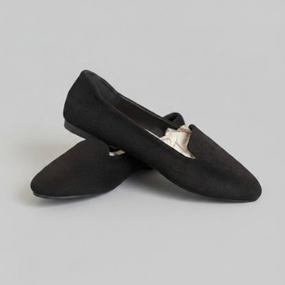 Pair of black slippers on a gray background