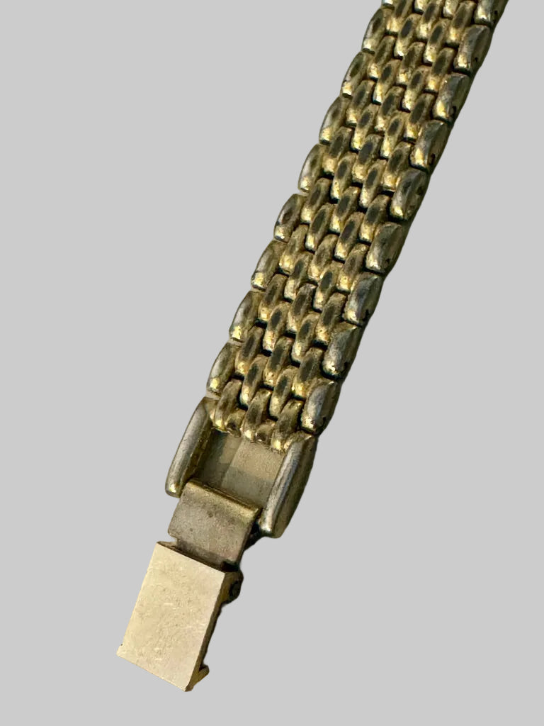 Close-up of a gold bracelet on a textured surface