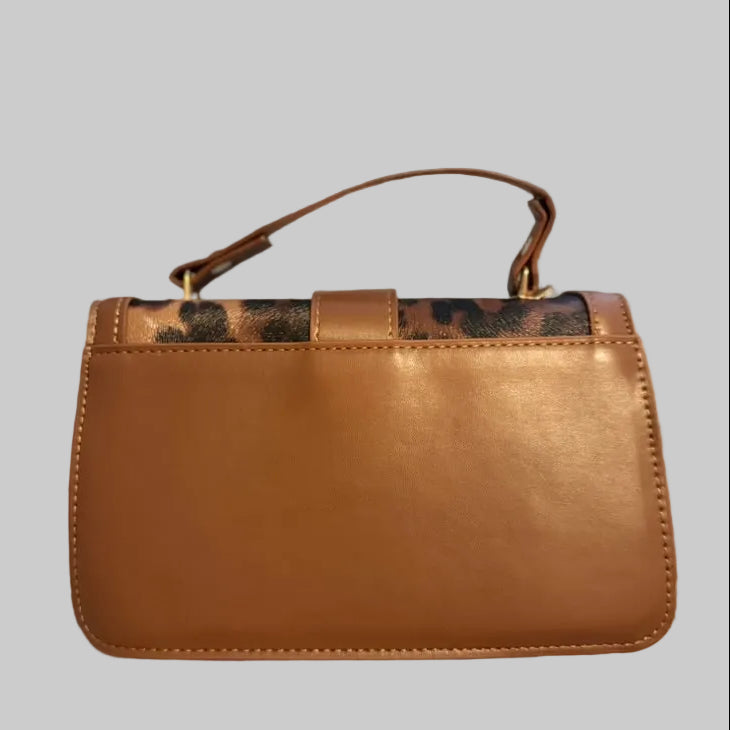 Brown handbag with a visible brand logo on a textured surface