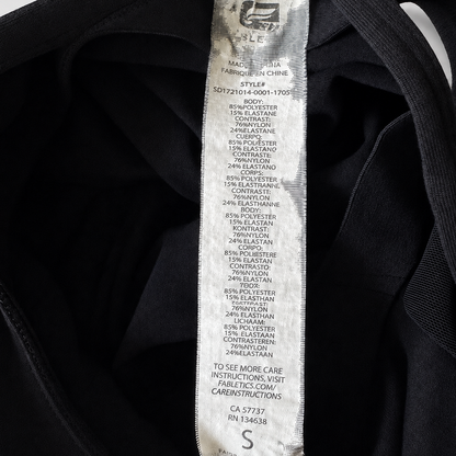 Close-up of the inner neck label of a black garment, showing the brand name Gildan and size information.