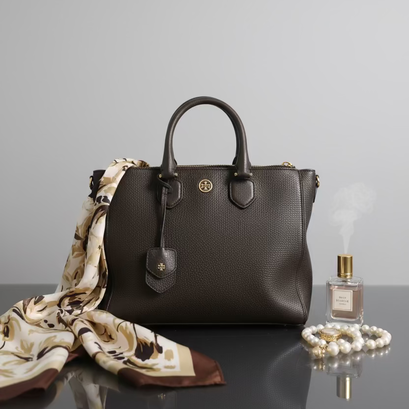 Black leather handbag with a brand logo on a textured surface