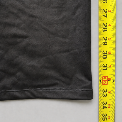 A close-up of a dark gray fabric item with a hemmed edge next to a yellow measuring tape to show the size.