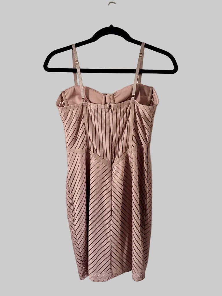 Pink dress with thin straps on a hanger against a white door.