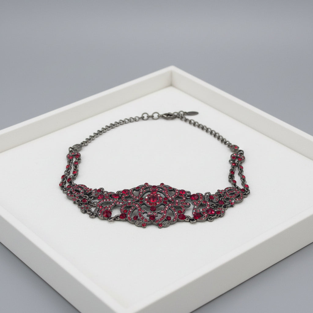 Decorative necklace with red gemstones on a jewelry tray