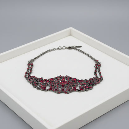 Decorative necklace with red gemstones on a jewelry tray