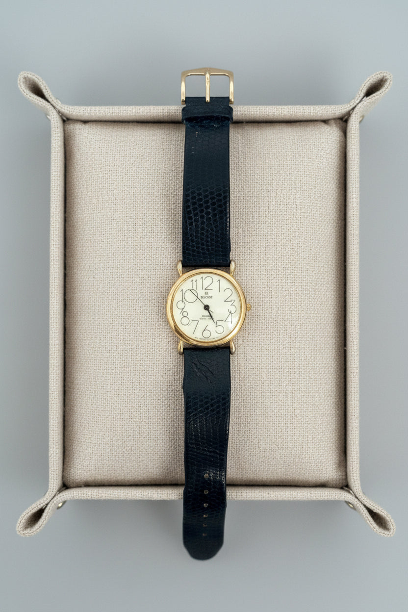 Vintage watch with black strap on a textured surface
