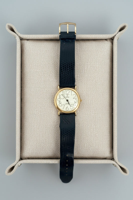 Vintage watch with black strap on a textured surface
