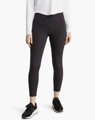 Person wearing black leggings with a white shirt on a white background