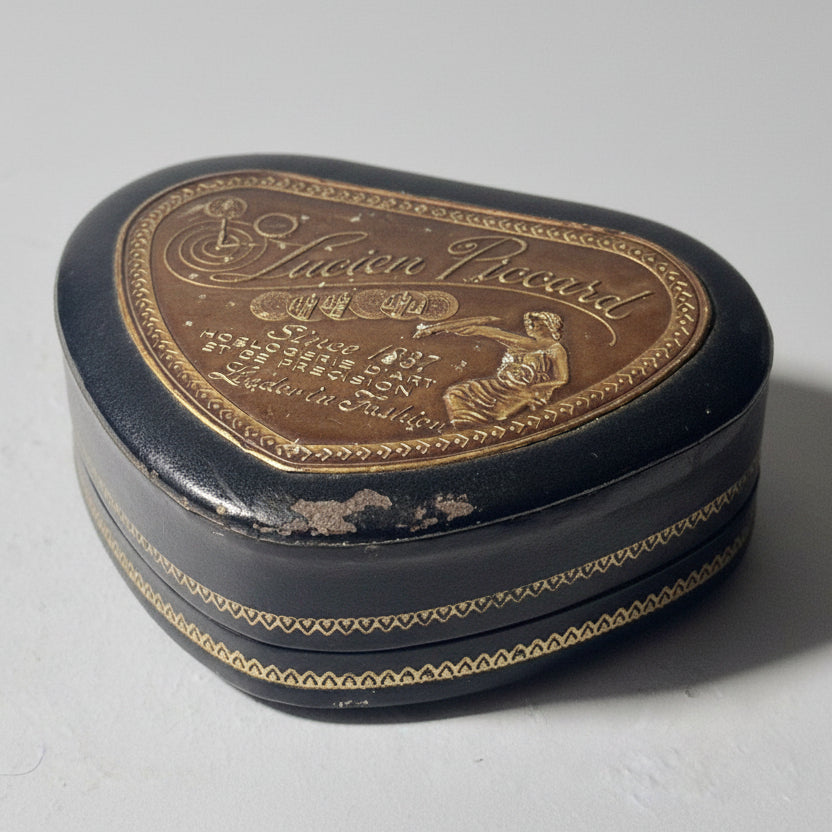 Decorative heart-shaped box with engraved text and design on a light background