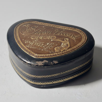 Decorative heart-shaped box with engraved text and design on a light background
