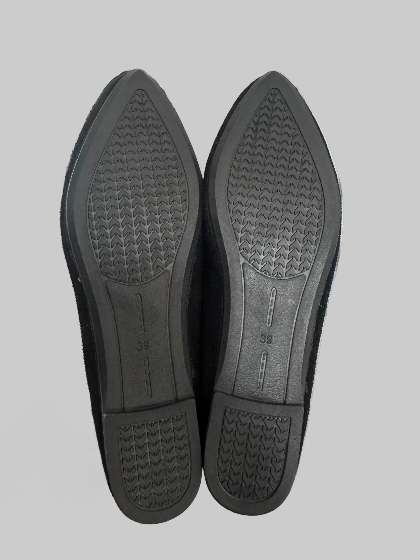 Black shoe insoles on a gray background