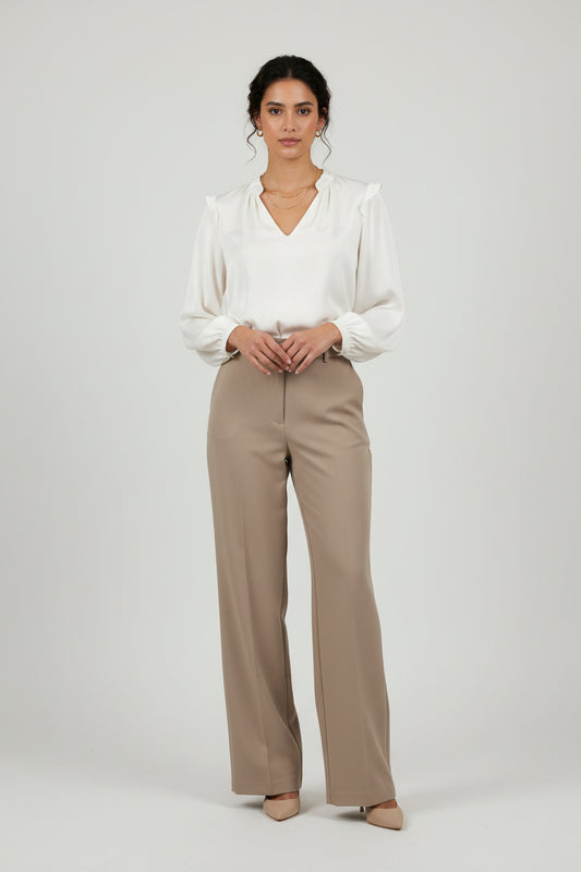 An off-white long-sleeve blouse with a split V-neckline, hanging on a black hanger against a plain light gray background.