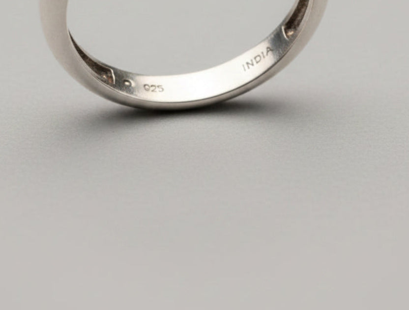 Close-up of a silver bracelet with '925' stamp on a blurred background