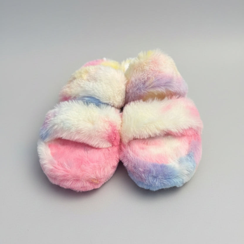 Pair of fluffy slippers with a tie-dye pattern on a gray background.