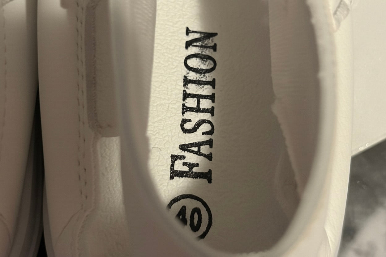 White shoe with 'FASHION' and a logo on the sole