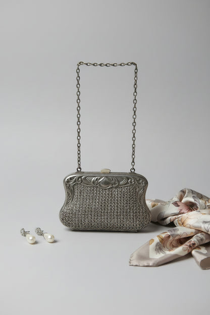 Vintage silver handbag with chain strap on a light gray background