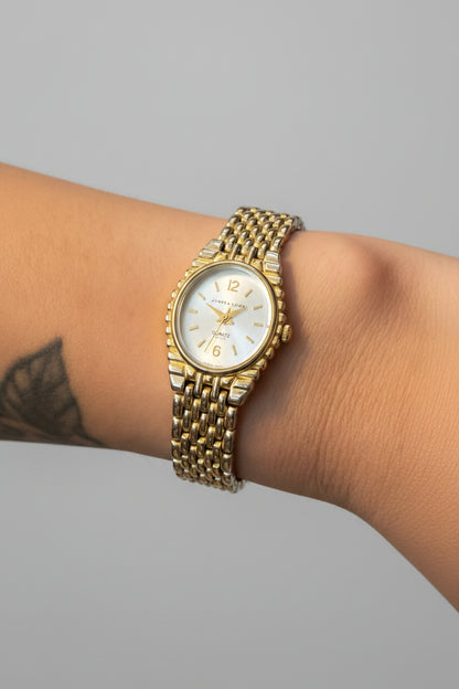Gold wristwatch on a person's wrist with a blurred background