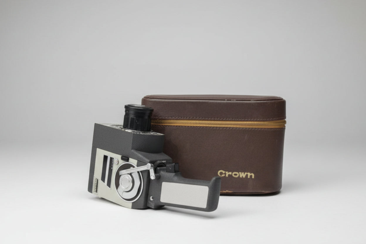 Vintage film camera and leather case on a gray surface.