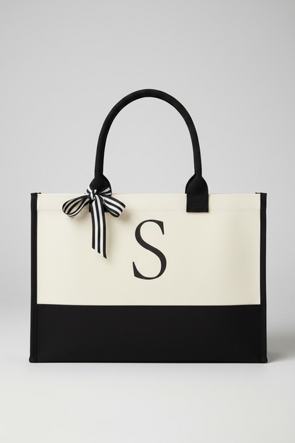 Black and white tote bag with a letter 'S' on a wooden surface
