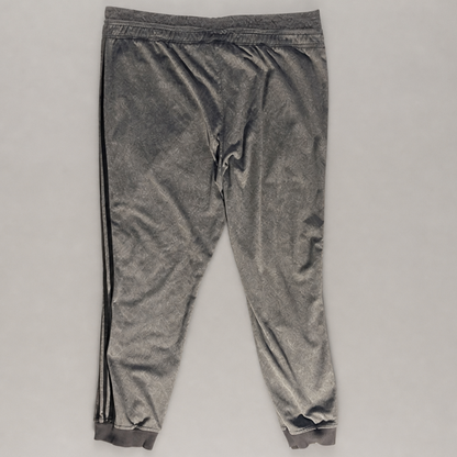 A pair of gray velvet jogger pants with black side stripes, laid flat on a light gray background.