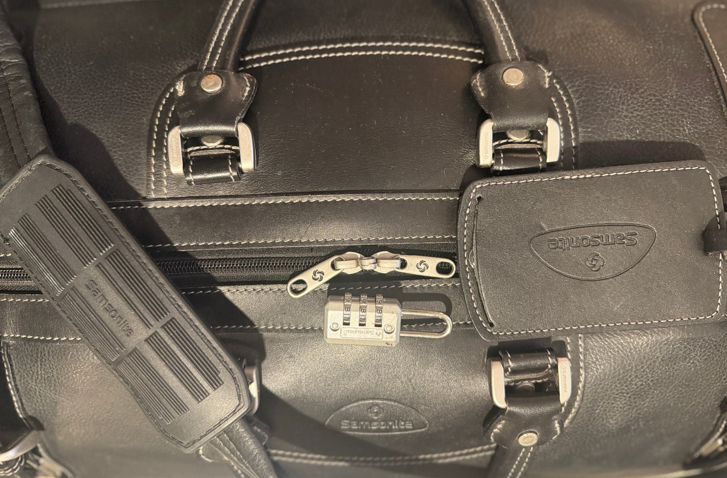 Black leather briefcase with Samsonite logo and combination lock.