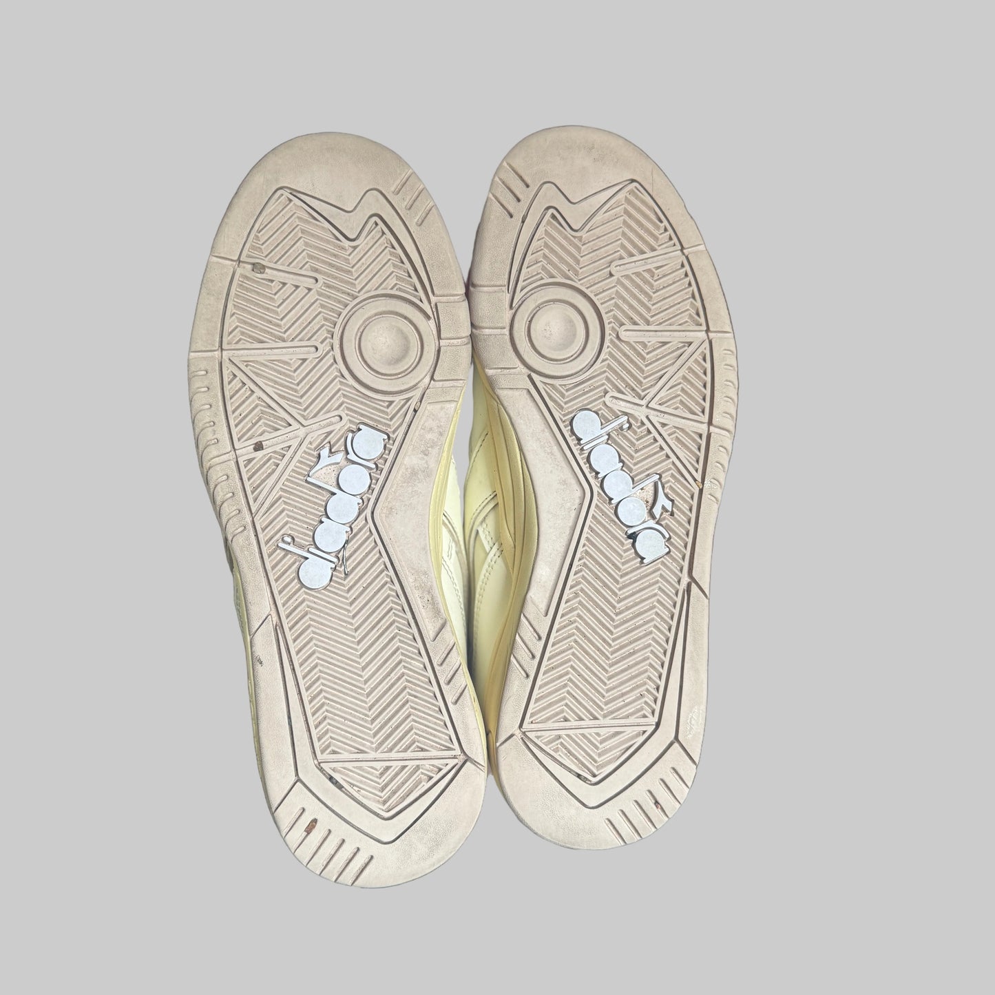 Close-up of a pair of beige shoes with tread pattern