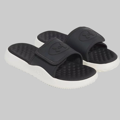 A pair of black slide sandals with textured footbeds and thick white soles, shown on a clean white background.