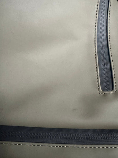 Close-up of a light gray fabric bag with a dark gray zipper and contrast stitching.