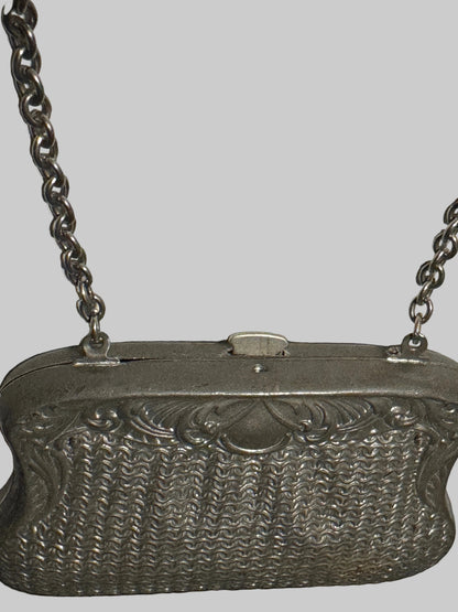Silver textured handbag with chain strap on a light background