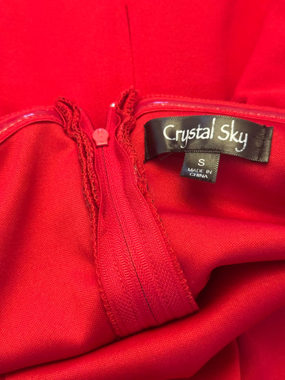 Close-up of a bright red garment with a black brand label reading Crystal Sky and a size tag reading S Made in China.