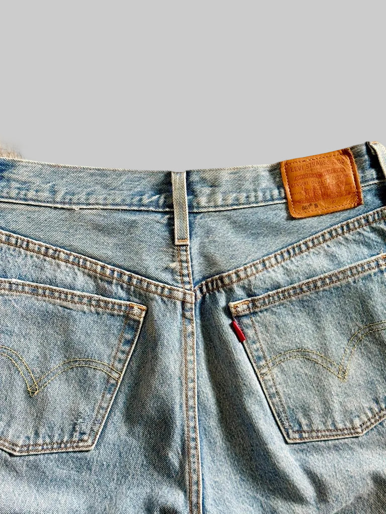 Close-up of a blue denim jeans with Levi's logo on a beige background