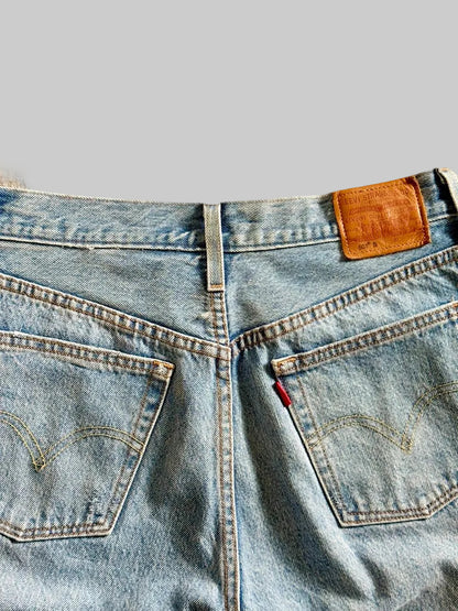 Close-up of a blue denim jeans with Levi's logo on a beige background