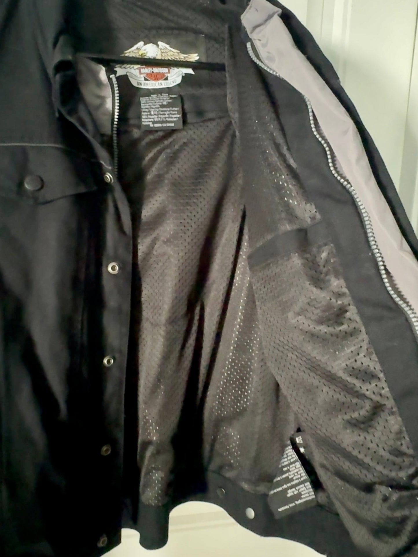 Black and gray jacket with mesh panels on a white surface