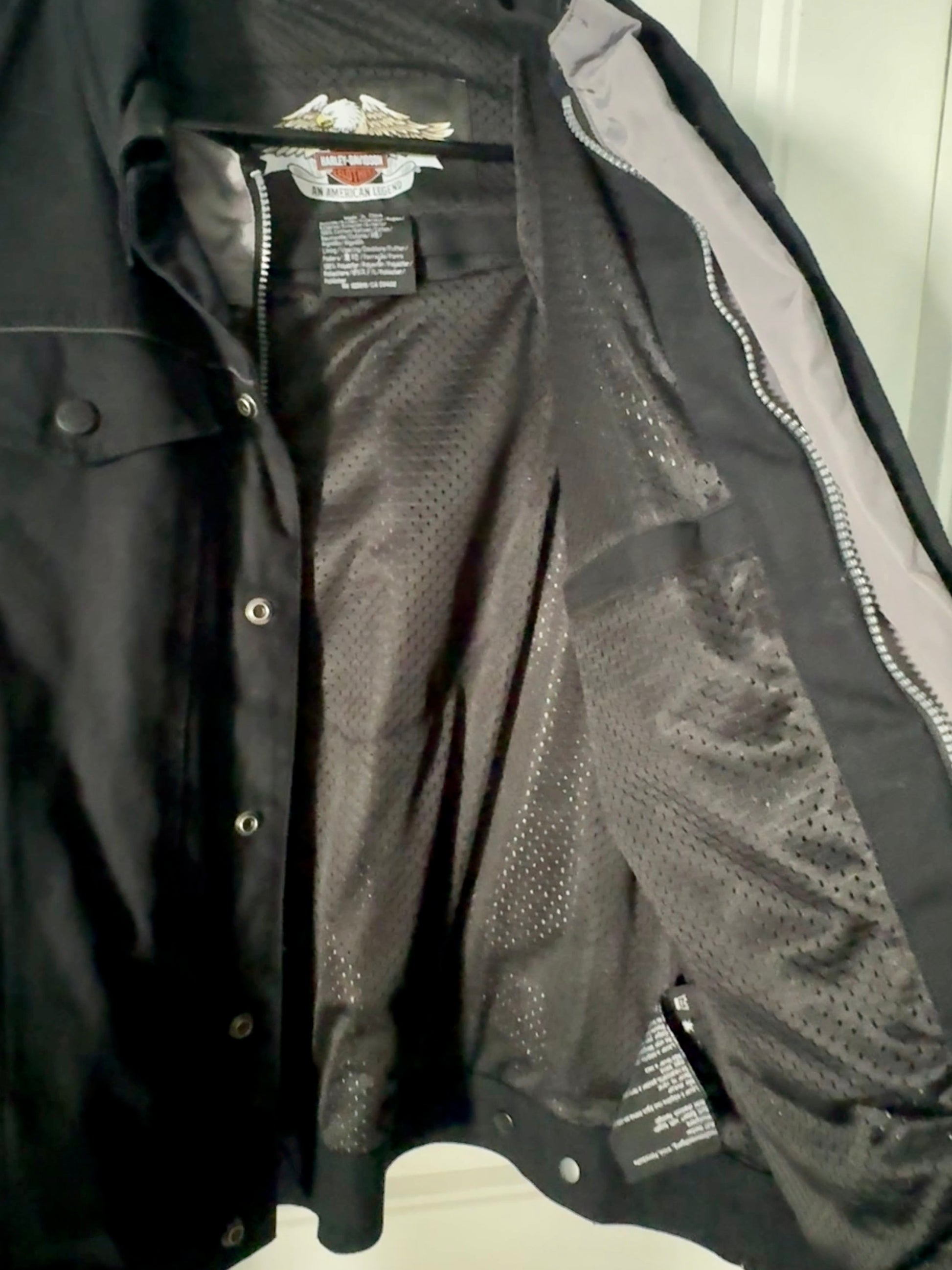 Black and gray jacket with mesh panels on a white surface