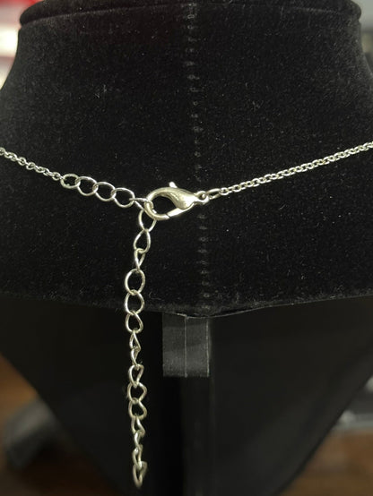 A silver chain necklace with a lobster clasp and extender chain, displayed on a black velvet jewelry bust.