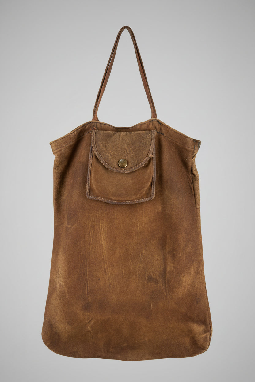 Brown leather bag on a light wooden surface