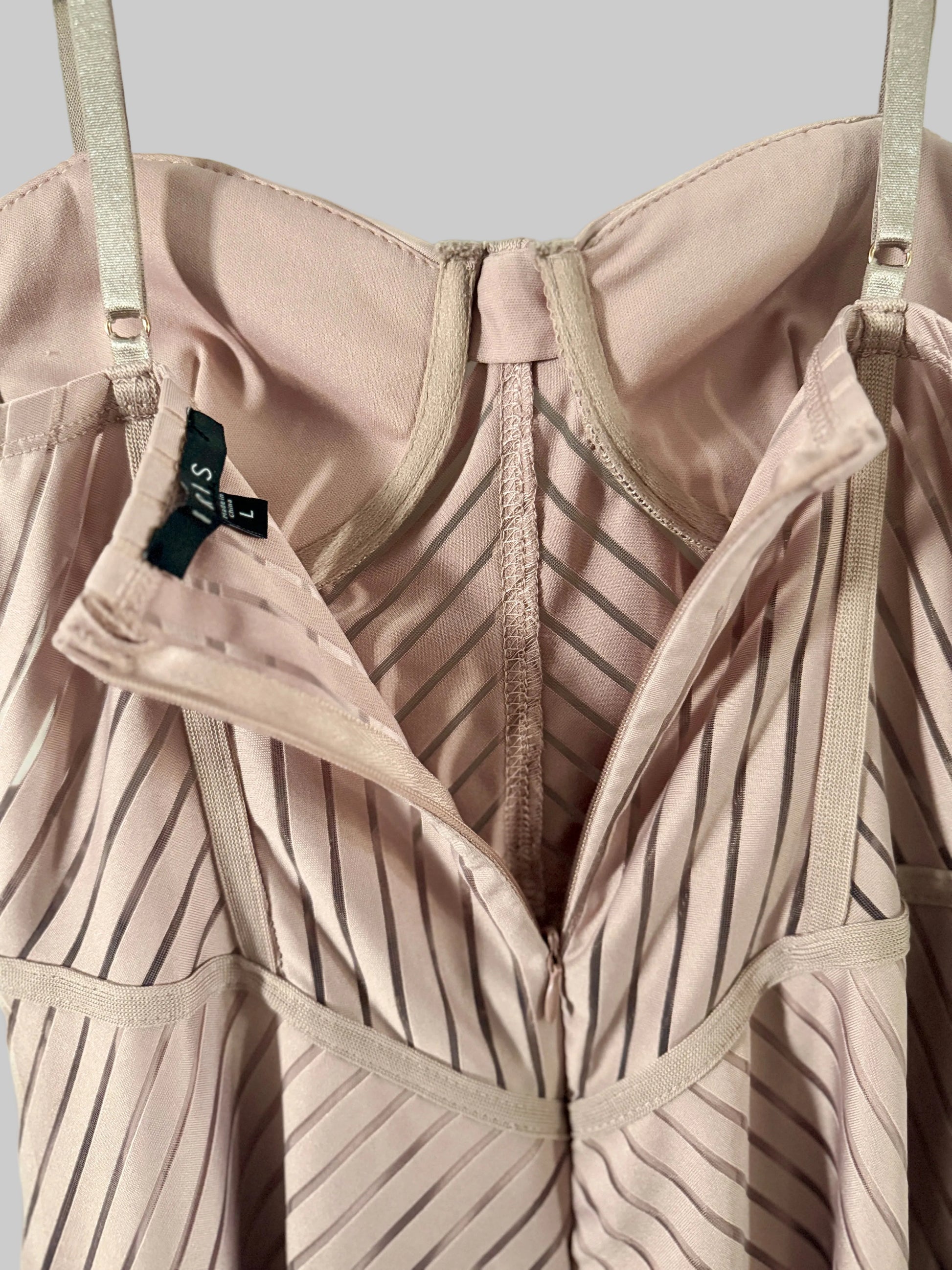 Close-up of a beige bra with a visible brand tag against a light green background