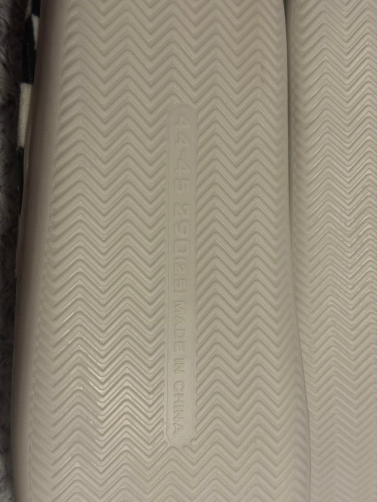Close-up of a textured off-white shoe sole with a chevron pattern and embossed vertical text reading 'MADE IN CHINA'.