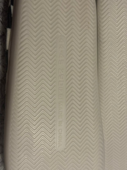 Close-up of a textured off-white shoe sole with a chevron pattern and embossed vertical text reading 'MADE IN CHINA'.
