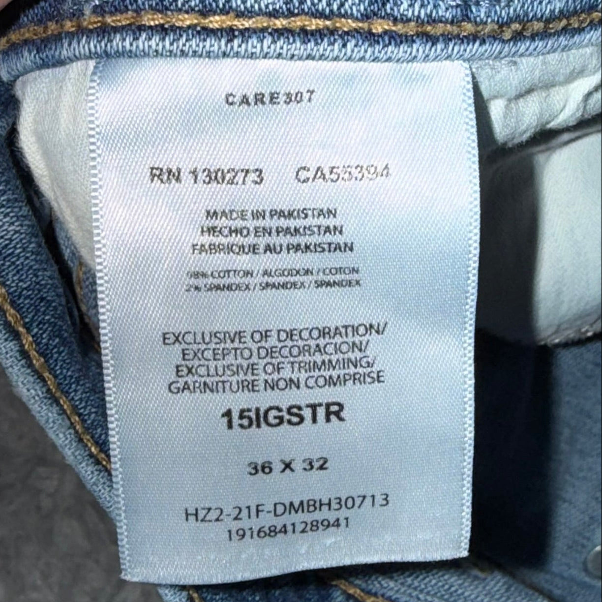 Close-up of a jeans label with text and size information.