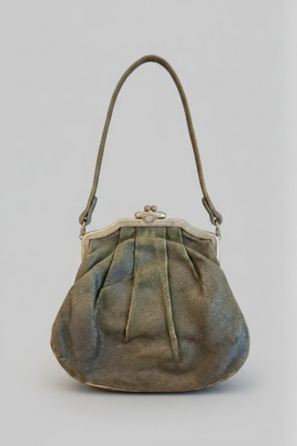 Vintage green handbag with a metal clasp on a gray background