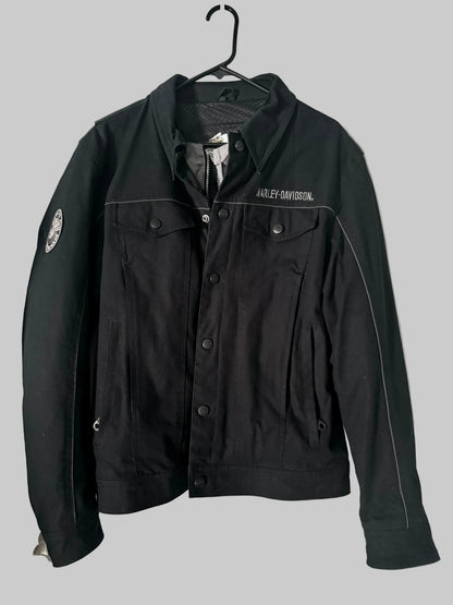 Black jacket with visible branding on a hanger against a white door background