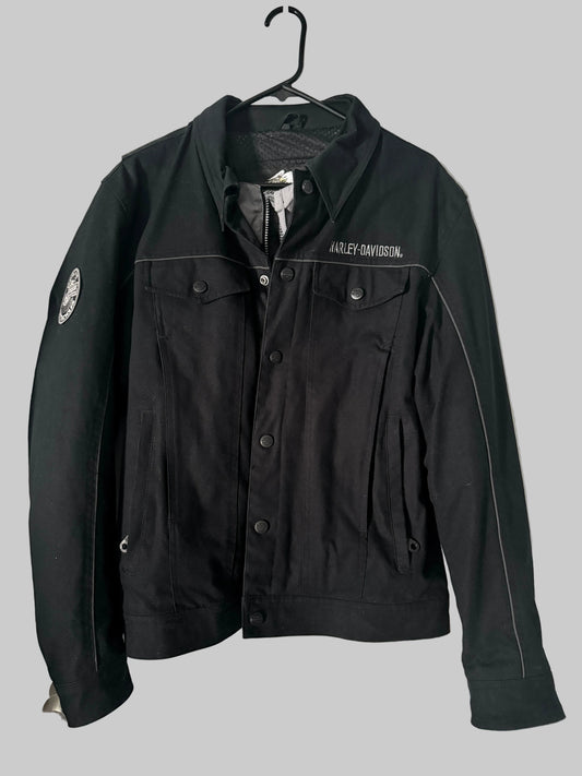 Black jacket with visible branding on a hanger against a white door background