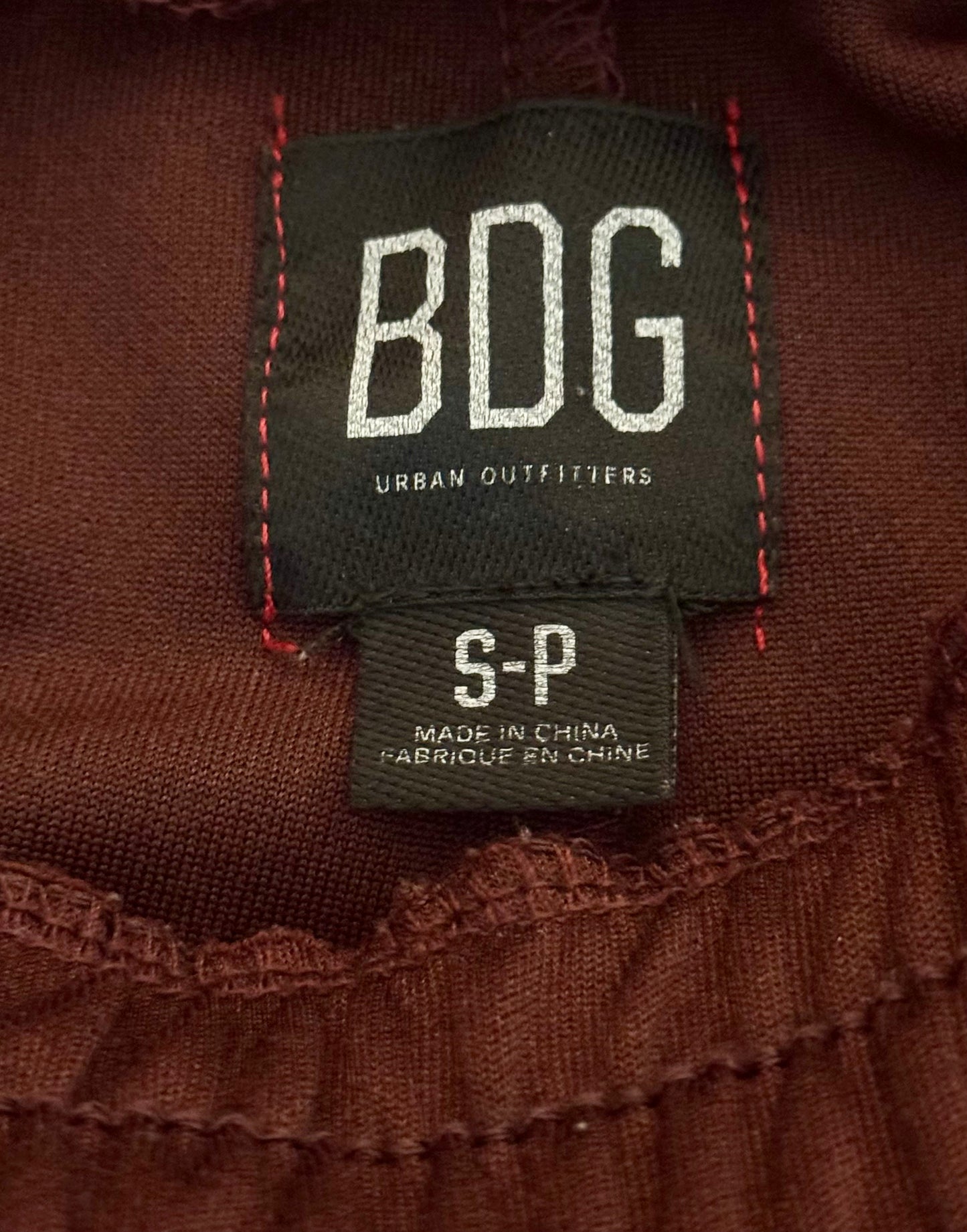 BDG Urban Outfitters label on a brown garment with 'S-P' and 'Made in China' text.