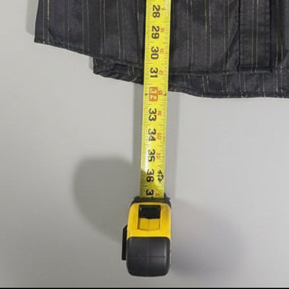 A black ribbed fabric item laid on a beige carpet with a yellow tape measure extended across it for size reference.