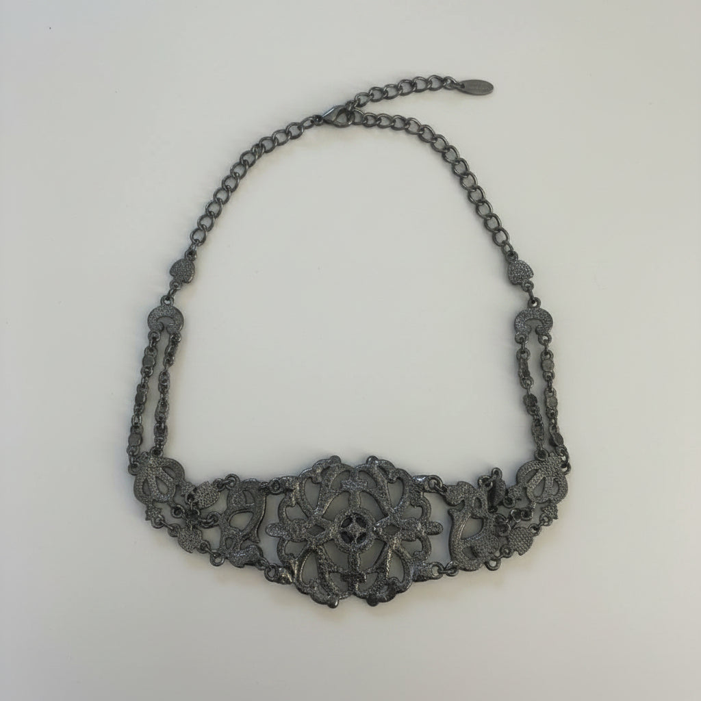 Back of Decorative necklace on a light wooden surface