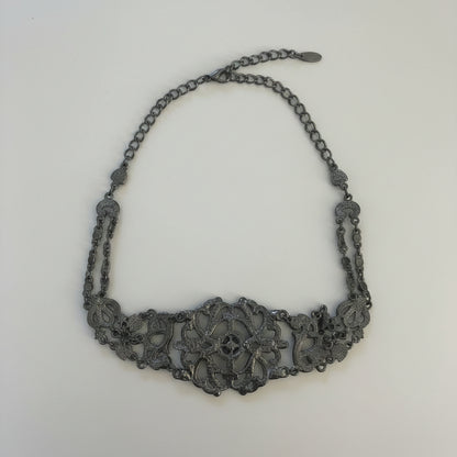 Back of Decorative necklace on a light wooden surface