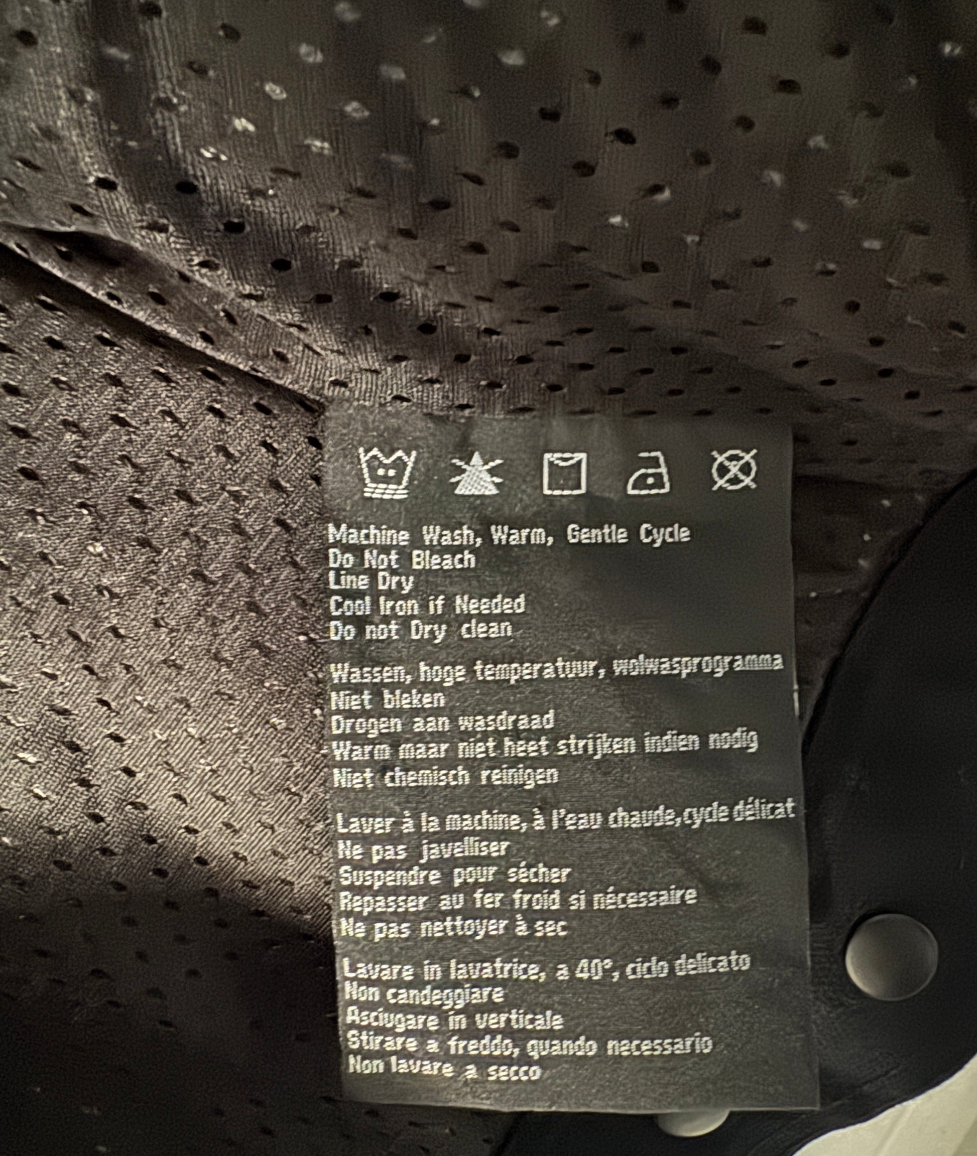 Clothing label with care instructions on a textured fabric background